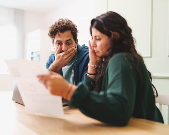 A young married couple worried looking at a medical bill