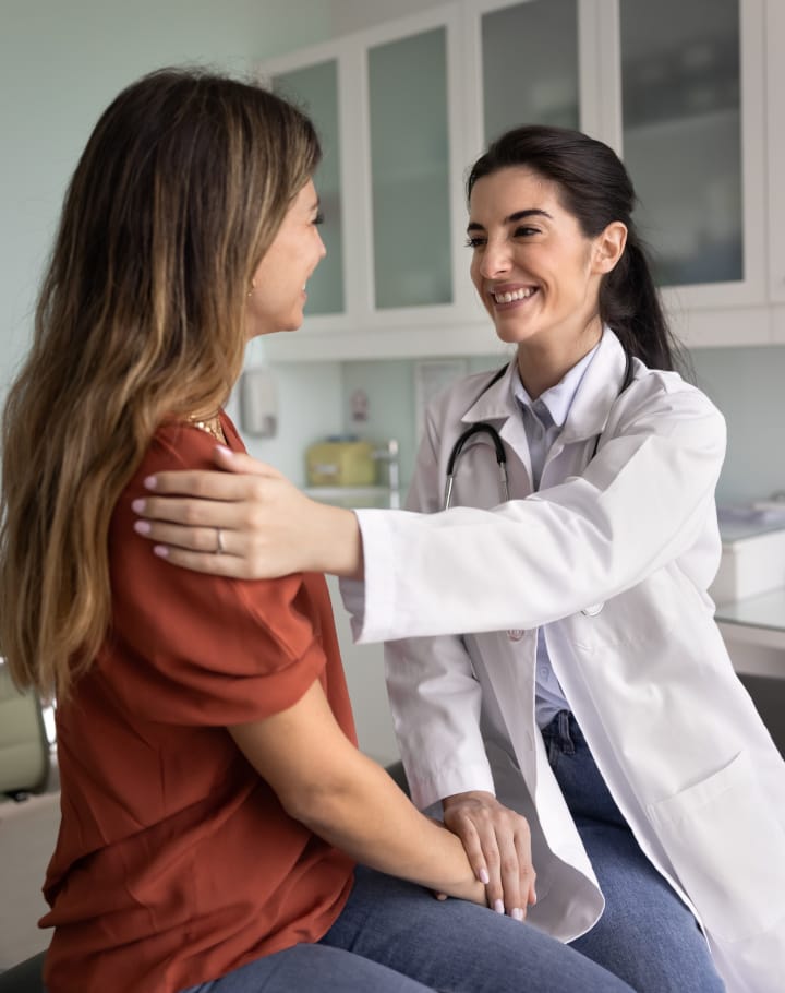 A female doctor comforting and reassuring a young female patient